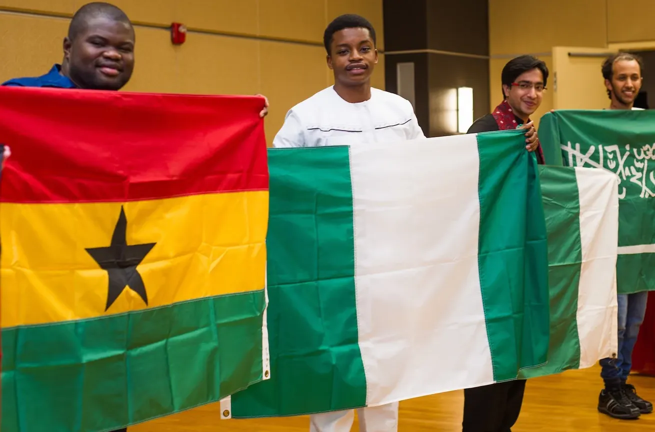 商业中心州立大学的国际学生举着国旗摆姿势